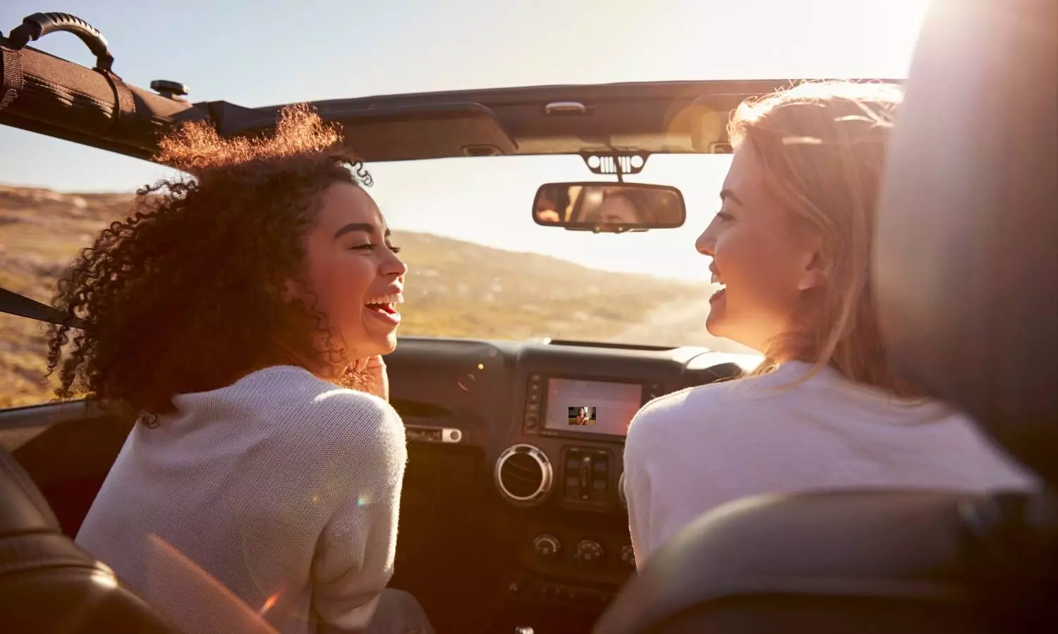 women cheering a car