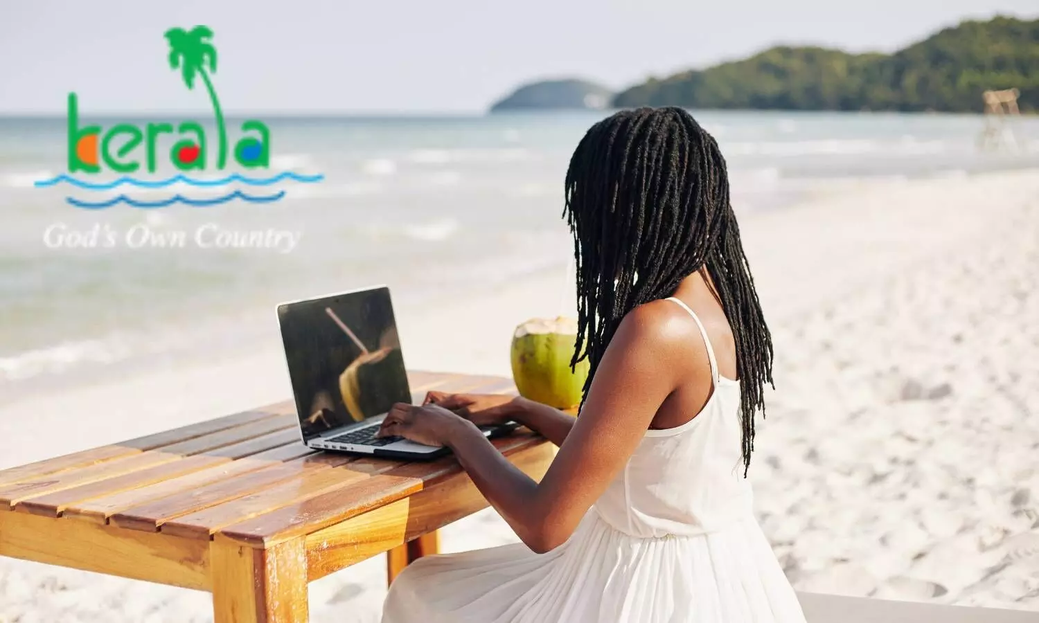 A girl sitting on beach with a laptop