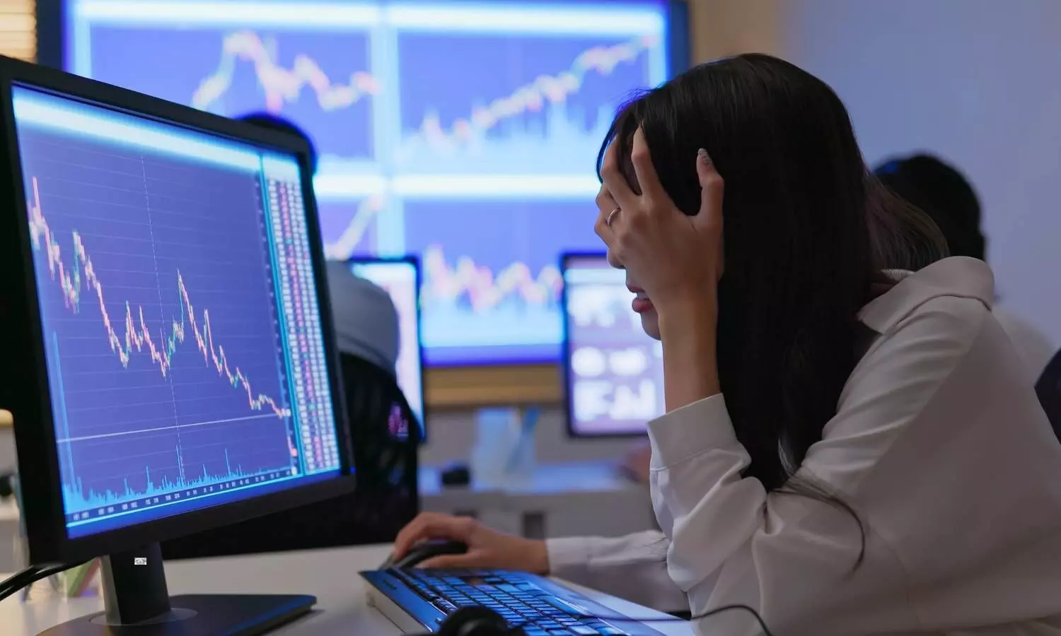 a women looking to a computer showing stock market crash